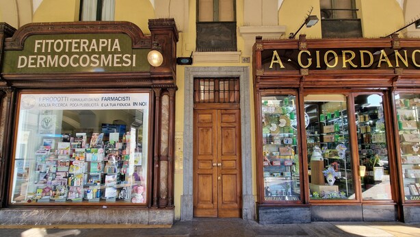 A storefront with a sign for 'Fitoterapia Dermocosmesi' and another for 'A Giordano.' - Bin Ciapà Apartment (Torino)