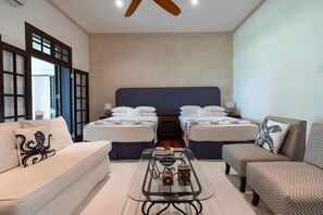 Ein Hotelzimmer mit zwei Betten, einem Sofa, einem Couchtisch und einem Sessel.