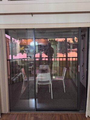 Ein Zimmer mit einer Schiebeglasdoor zu einem Außenbereich mit Tisch und Stühlen.