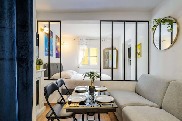 A dining area with a table set for four, a sofa, a mirror, and a plant. - Peaceful haven in the heart of Old Nice (Nice)