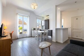 Un apartamento moderno con comedor, cocina y sala de estar con sofá y sillón.