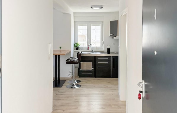 Une cuisine moderne avec un tabouret de bar, un évier et une fenêtre.