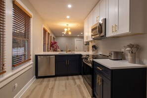 A modern kitchen with a dishwasher, stove, microwave, and a sink. - Spacious 3BR Duplex - Walk to Armature + Riverwalk (Tampa)