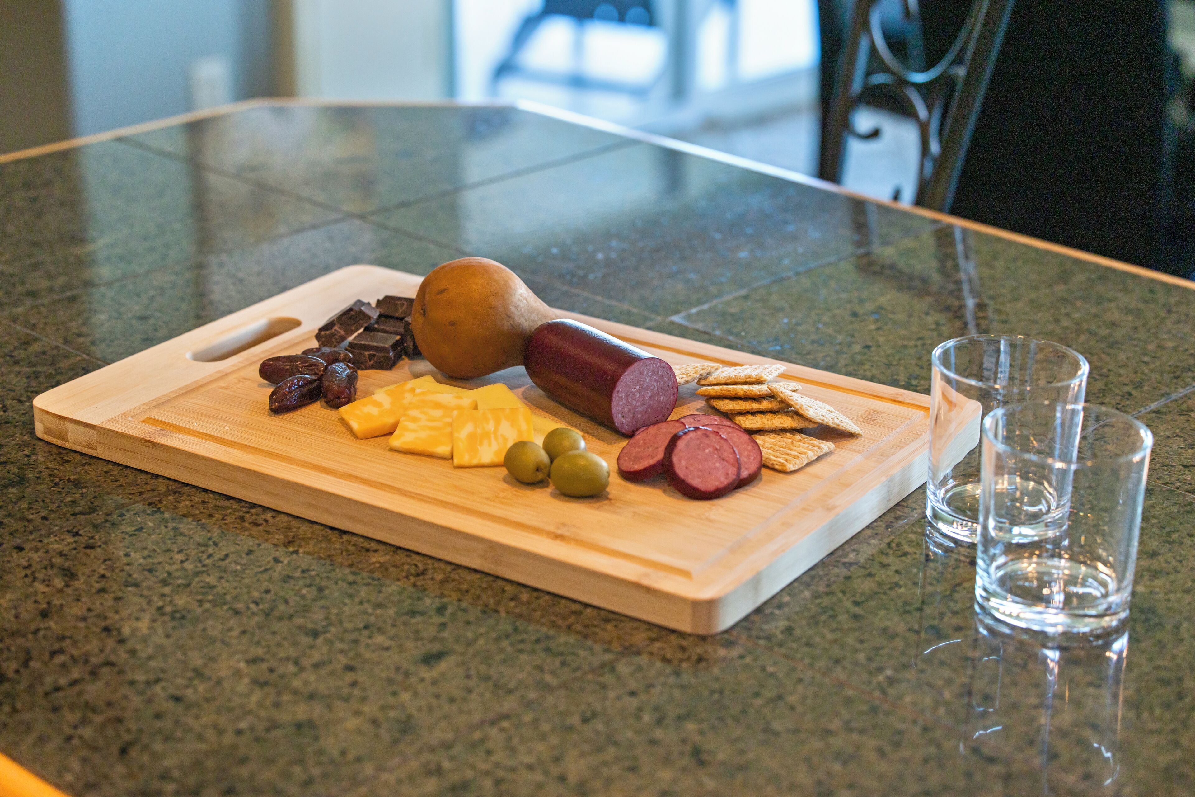 A wooden cutting board with various food items on a kitchen counter.