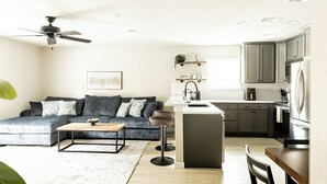 Una cocina moderna con barra, una mesa de comedor y un sofá en la sala de estar.