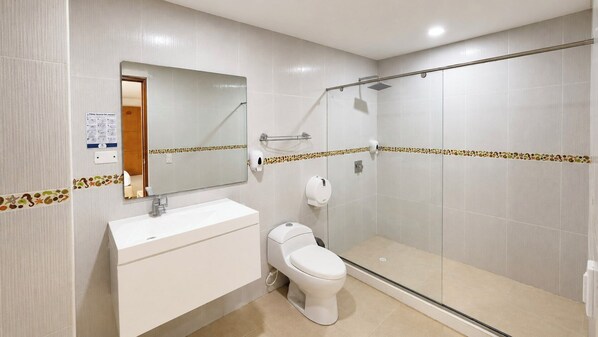 A bathroom with a shower, toilet, sink, and mirror. - Vadamar Hotel Collection Rodadero (Santa Marta)