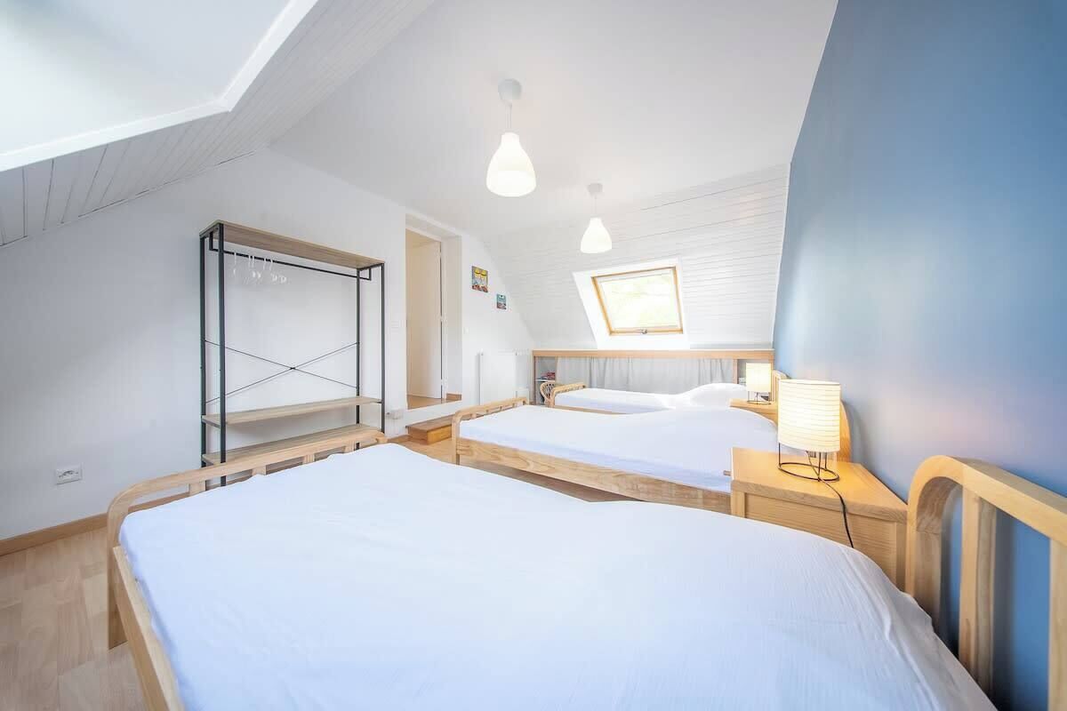 Ein Zimmer mit zwei Betten, einem Oberlicht, einem Kleiderschrank und einem Nachttisch mit Lampe.