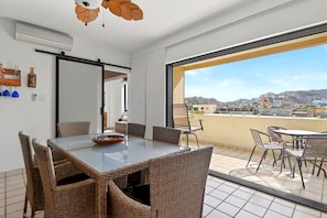 Un apartamento moderno con zona de comedor, un balcón con vistas y un amplio ventanal corredero.