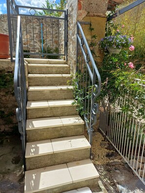 Eine Treppe mit Metallgeländern, die zu einer Steinmauer führt.