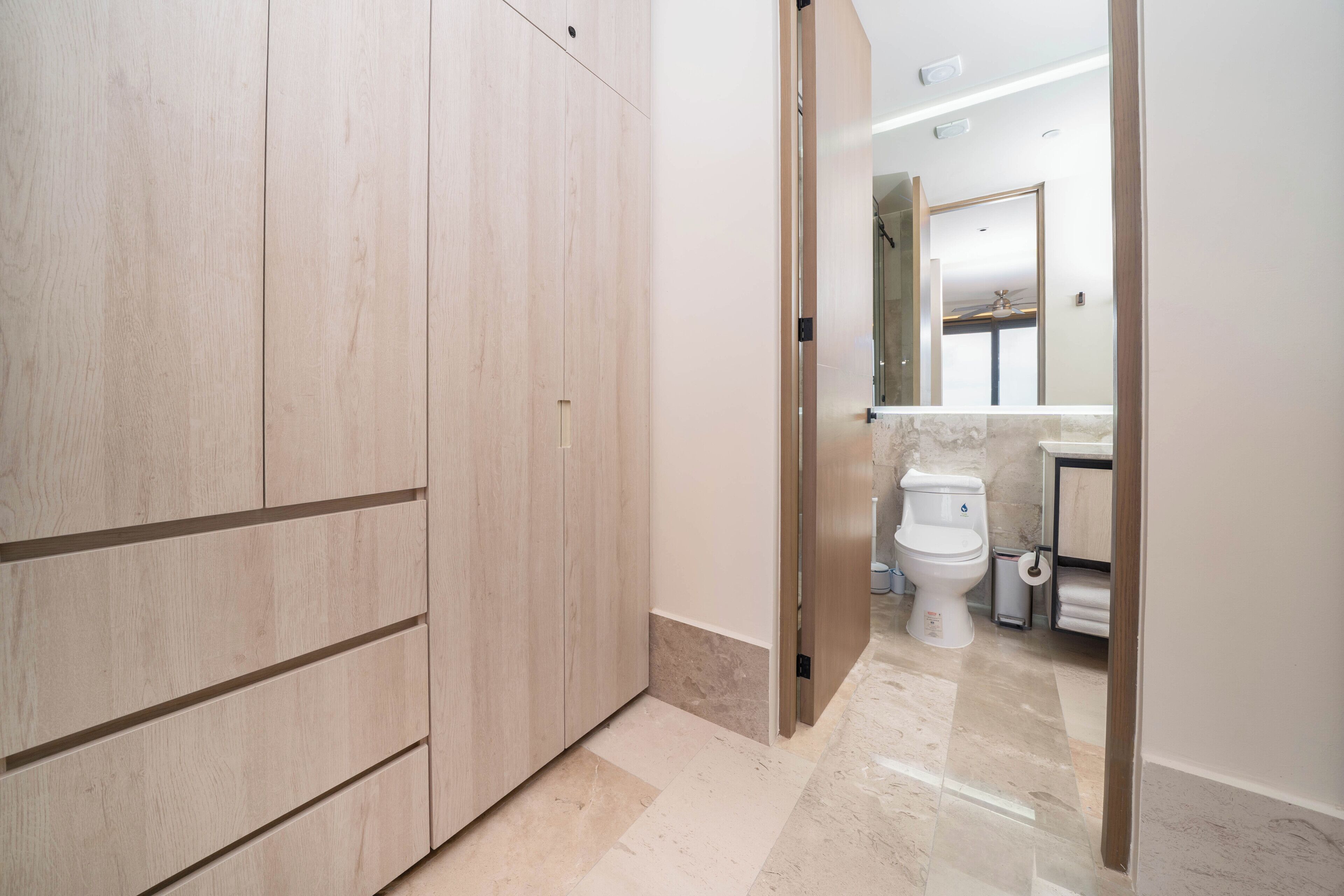 Une salle de bain moderne équipée de toilettes, d’un lavabo et d’un miroir.