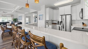 A modern kitchen with white cabinetry, stainless steel appliances, and a central island.