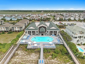 A resort with a large central pool, multiple guest rooms, and a boardwalk leading to the pool.