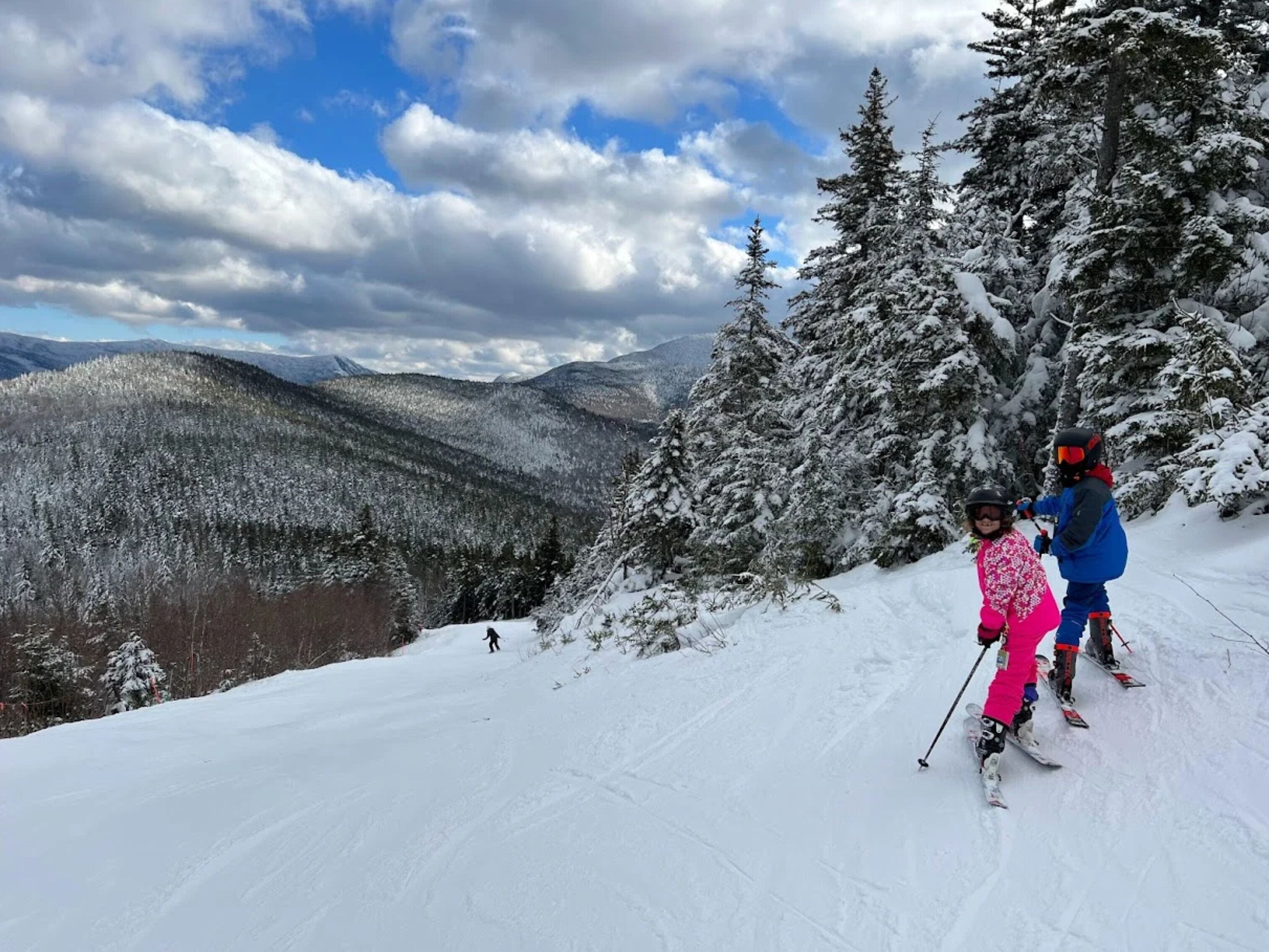 A snowy mountain landscape with skiers.
