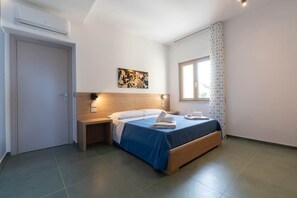 A hotel room with a bed, bedside tables, a window with curtains, a painting on the wall, and an air conditioning unit. - Alexandr Azure House (Pizzo)