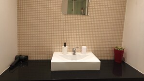 A bathroom with a white sink, a mirror, and a potted plant. - Happy@chiadosuites12 (Lisboa)