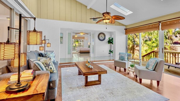 A spacious living area with a high ceiling, a ceiling fan, and a large window offering a view of the outdoors. - Paradise Palms: Pool, Game Room, & Minutes to Siesta Key Beach! (Siesta Key)