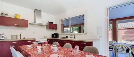 A compact kitchen with a dining area, a window, and a view of the outdoors.