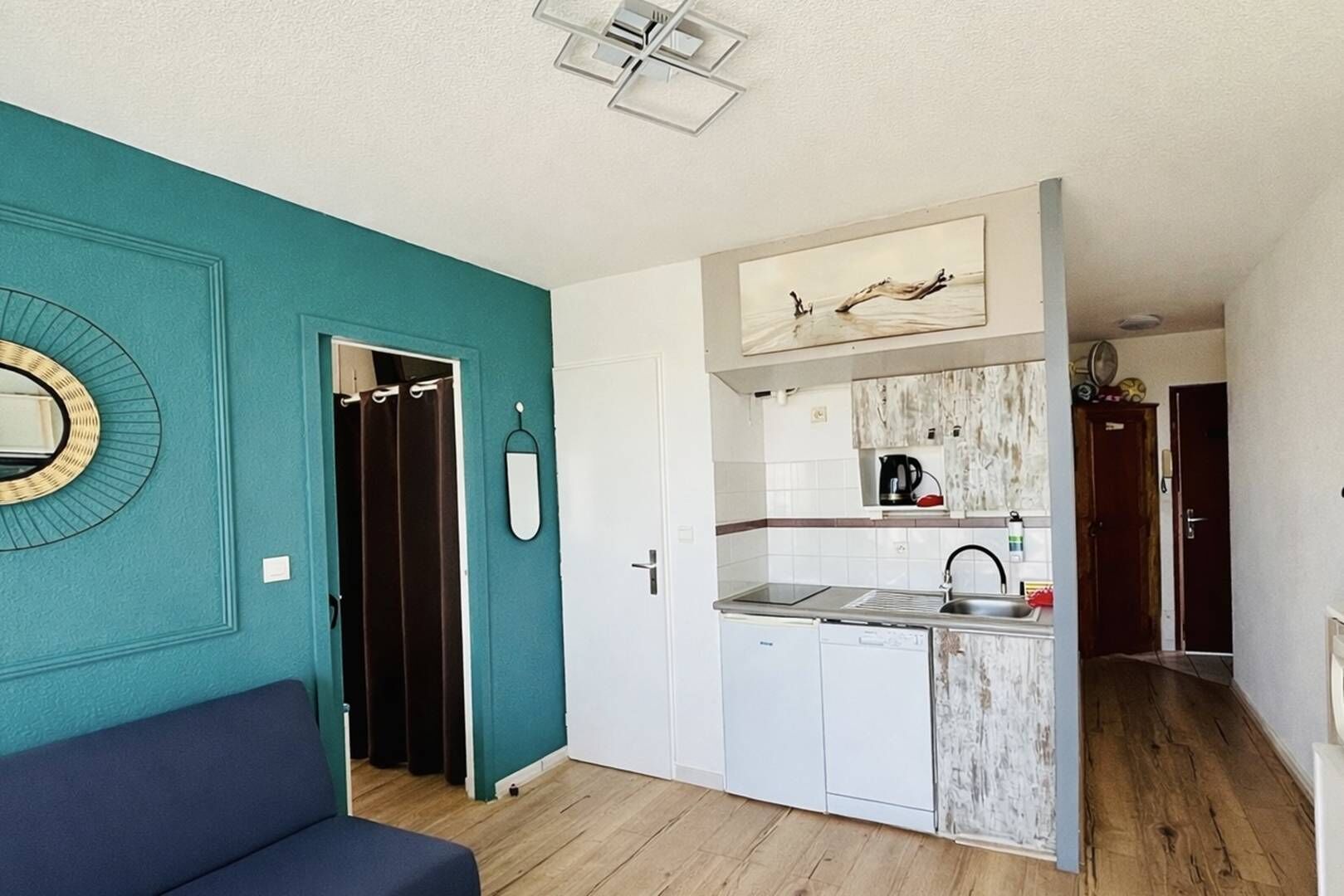 Un espacio habitable compacto con kitchenette, comedor y baño.