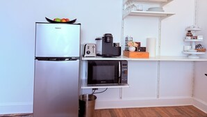 Una cocina compacta con refrigerador Galanz, una tostadora, una cafetera y un microondas.