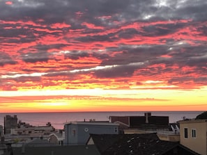 Eine Küstenstadtlandschaft mit Gebäuden und einem Sonnenuntergang.