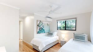 A bedroom with a bed, a ceiling fan, a window with a view, and a painting on the wall. - Unit 1, 9 Hill Street, Sunshine Beach (Sunshine Beach)