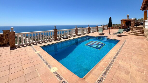 A swimming pool with a view of the sea, a white balustrade, and a tiled deck. - Pet friendly home in Almuñecar (Almuñecar)