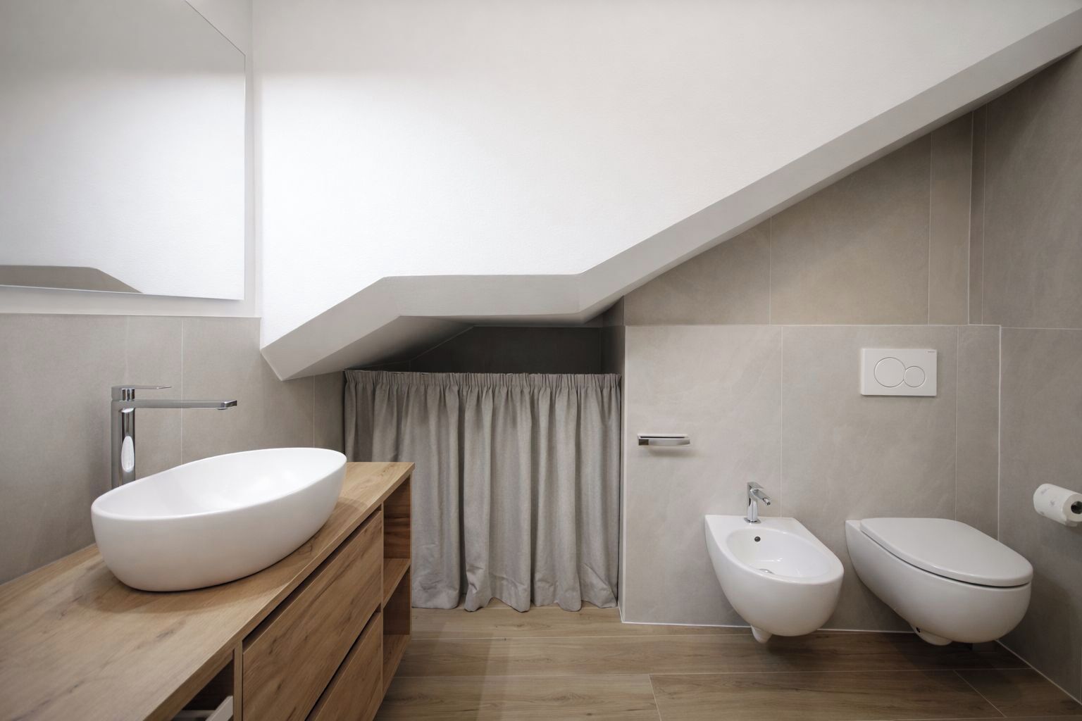 Un bany modern amb un rentapeus independent, un vàter i un lavabo.