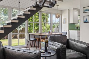 A modern kitchen with a dining area, a staircase, and a view of the outdoors. - Yakima Valley Views with Pool and Sauna (Yakima)
