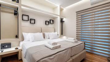 A modern hotel room with a large bed, bedside tables, a wardrobe, and a window with blinds.