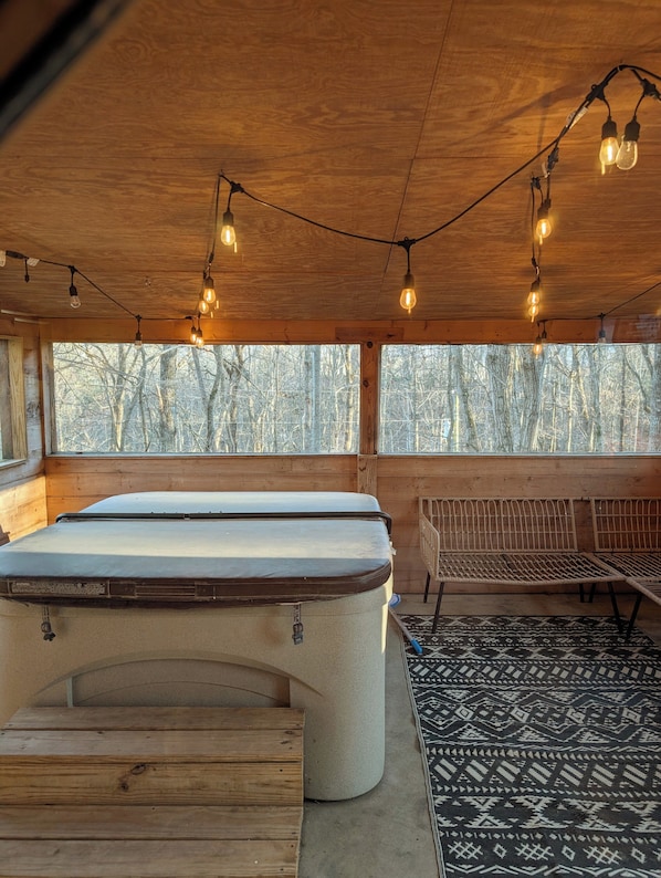 Ein gemütliches Zimmer mit Billardtisch, Holzbänken und Lichterketten.