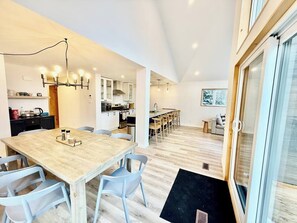 Una cucina moderna con zona pranzo, pavimento in legno e una grande finestra.
