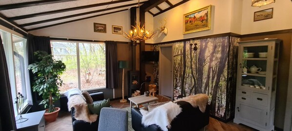 TV, fireplace - The De Bosduif bungalow accommodates four people and is situated in a very open and spacious setting. The luxurious furnishings make your stay especially comfortable. The beautiful glass wall with French doors brings the outdoors inside. (Hoge Hexel)