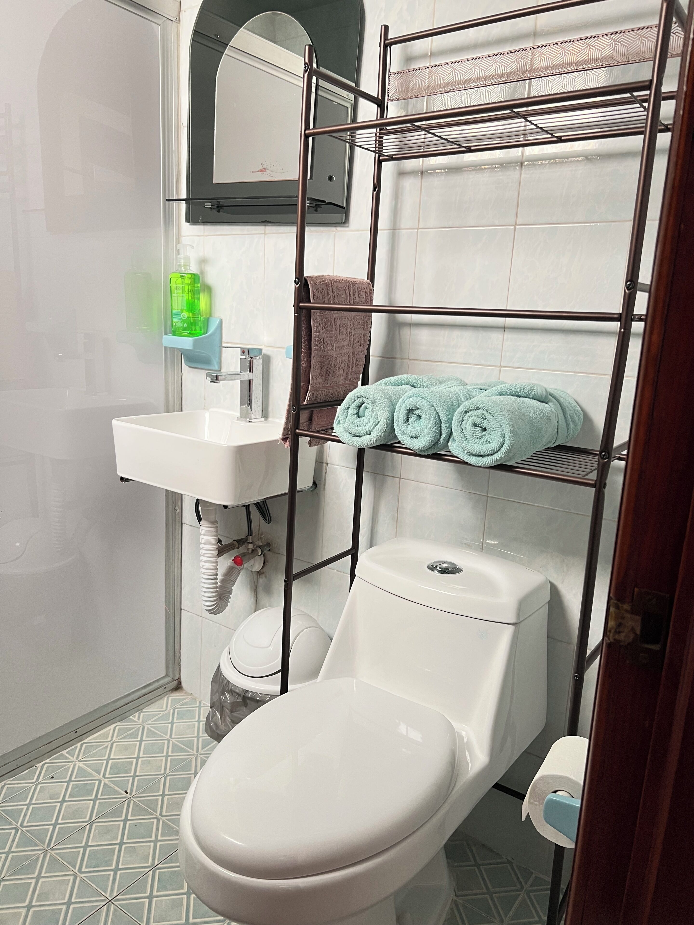 A bathroom with a toilet, sink, and towel rack.