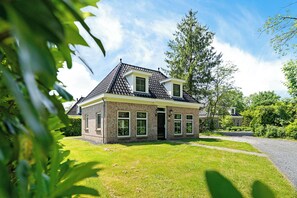 Ein zweigeschossiges Haus mit Ziegelaußenwand, Satteldach und Vordergarten.