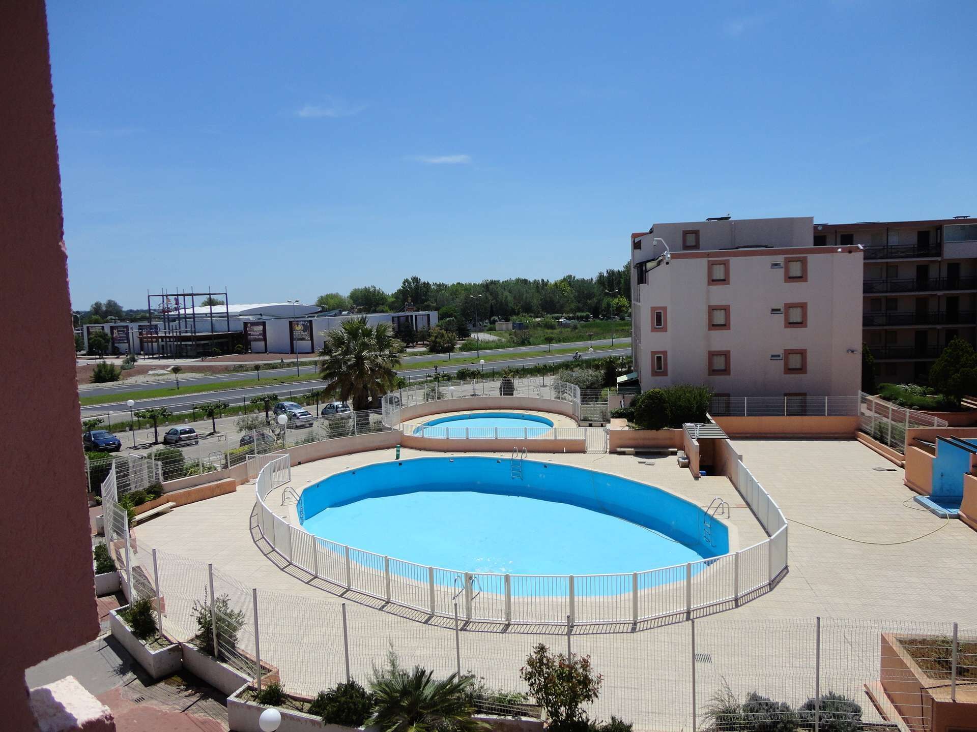 A rooftop swimming pool with a clear view of the surrounding buildings and road.