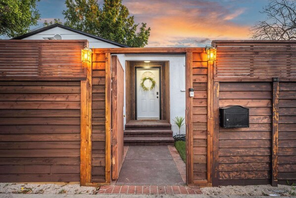 A wooden house with a white door, a wreath, and a mailbox. - Chic 3BR Hollywood Escape w/ Pool + Private Patio (Los Angeles)