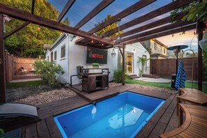 A backyard with a swimming pool, wooden deck, and a Netflix sign. - Chic 3BR Hollywood Escape w/ Pool + Private Patio (Los Angeles)