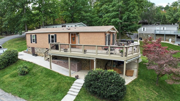 Une maison à deux étages dotée d’un balcon, de fondations en pierre et d’une pelouse bien entretenue.