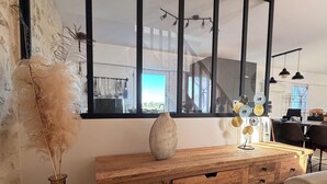 En trækommode med skuffer, en vase med pampasgræs og et stort spejl med sort ramme.