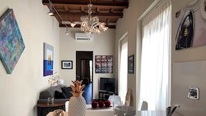 Una cocina moderna con una isla central, un comedor con sofá y una sala de estar con chimenea.