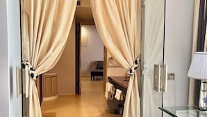 A hotel room with a glass shower enclosure, a wooden bench, and a bathroom counter with towels. - Binh An Village Dalat Resort (Da Lat)