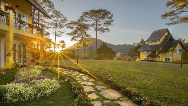 A residential area with a well-maintained lawn, stone pathway, and houses with balconies. - Binh An Village Dalat Resort (Da Lat)