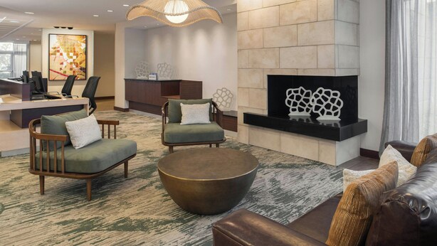 A modern lobby with a reception desk, seating area, and a fireplace. - Fairfield Inn & Suites Tampa Westshore / Airport (Tampa)