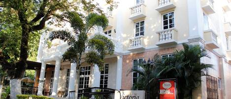 A hotel with a white facade, columns, and balconies.