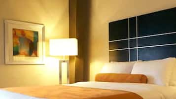 Ein Hotelzimmer mit Bett, Nachttisch, Lampe und einem Bild an der Wand.