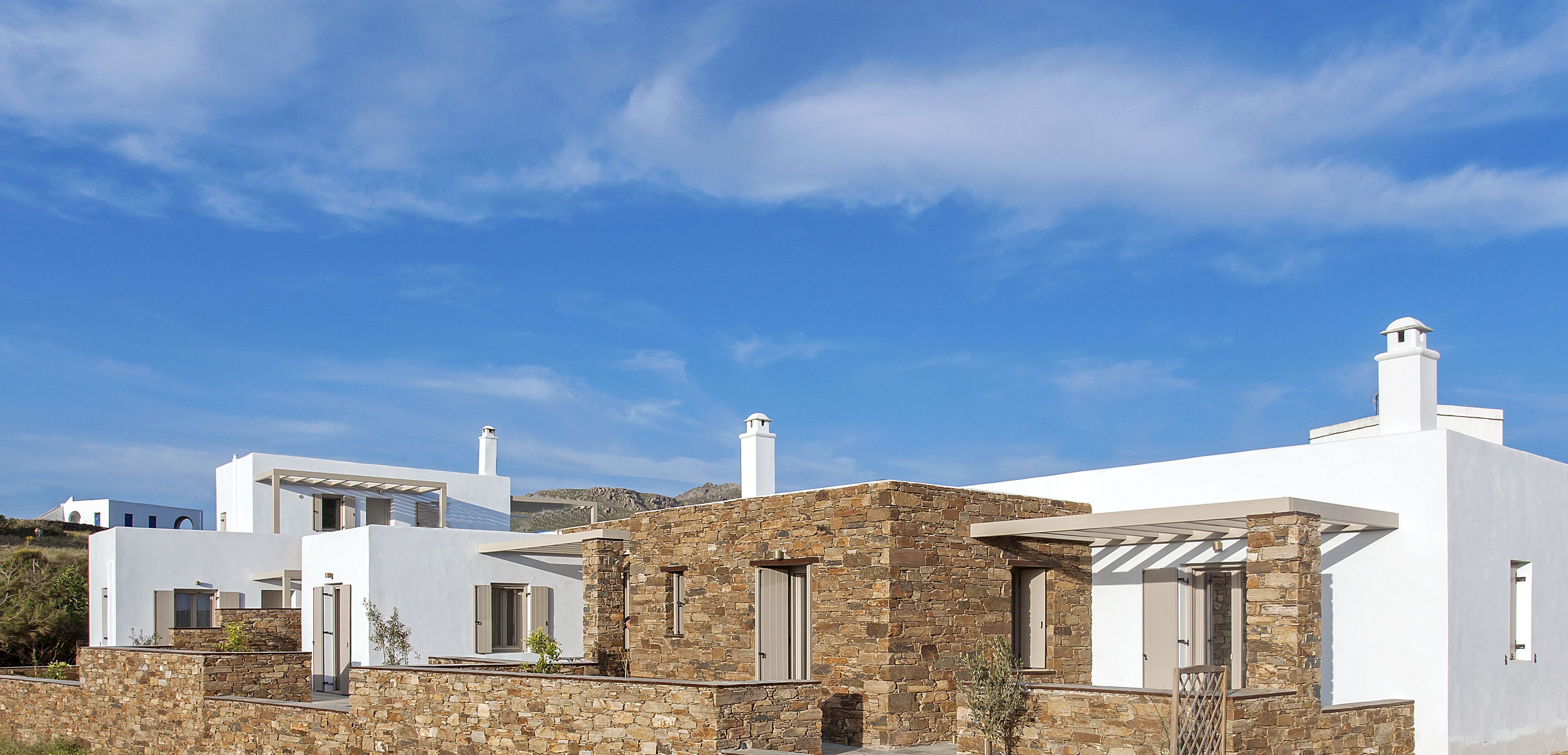 Un edificio moderno blanco con detalles de piedra y un cielo azul despejado.