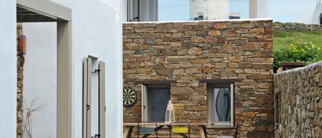 A modern house with a stone facade, a green lawn, and a view of the sea.