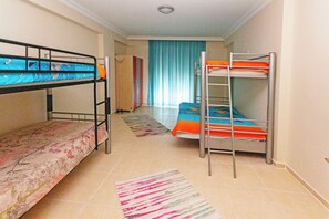 A dormitory room with bunk beds, a striped rug, and a blue curtain. - Paradise Town Villa Alison (Serik)