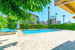 A swimming pool with lounge chairs and a pergola. - Paradise Town Villa Alison (Serik)