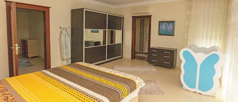 A bedroom with a bed, wardrobe, and a mirror.